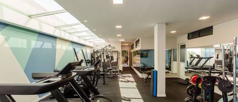 A gym with treadmills, weight machines, and free weights.