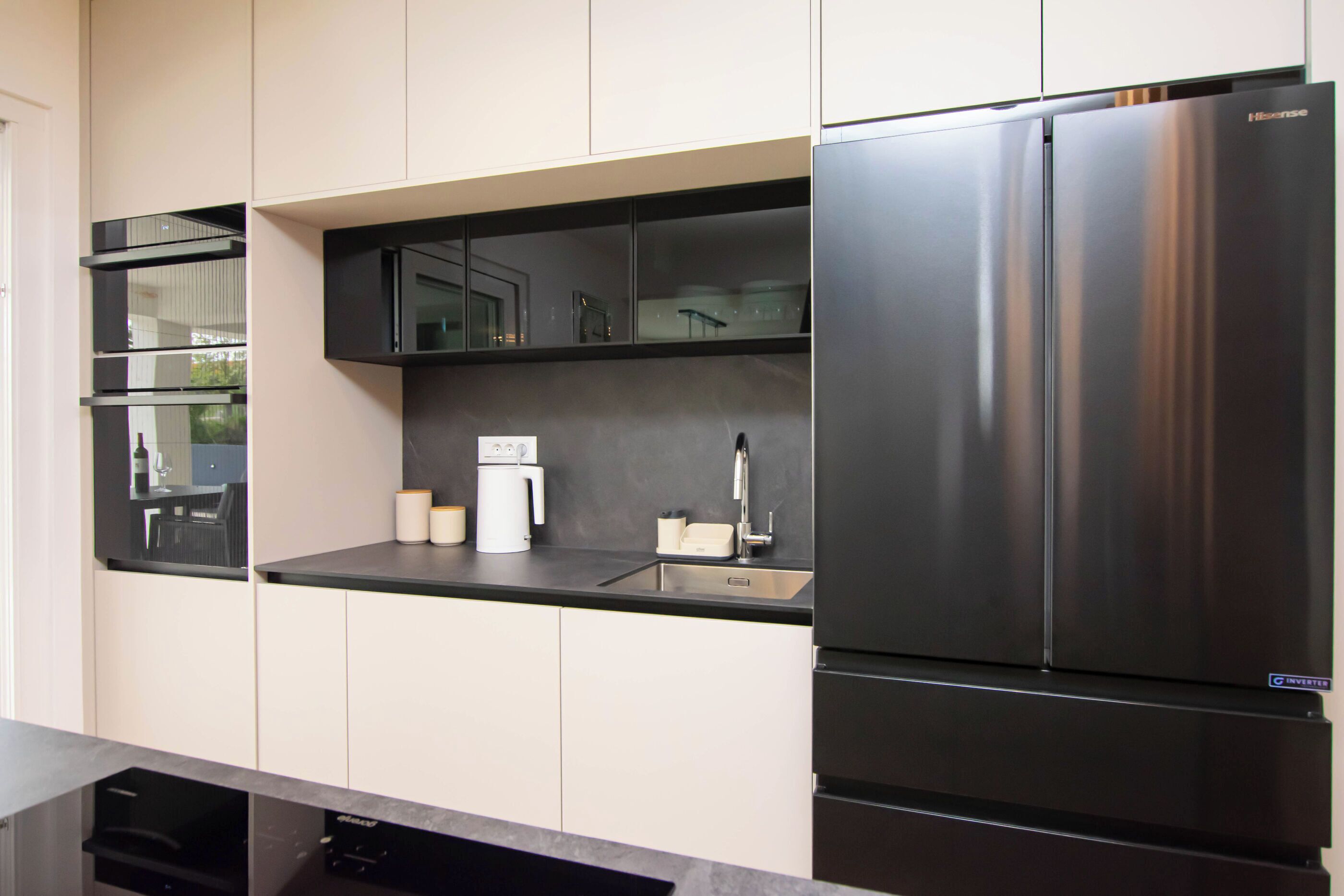 A modern kitchen with a stainless steel refrigerator, a built-in oven, and a dishwasher.