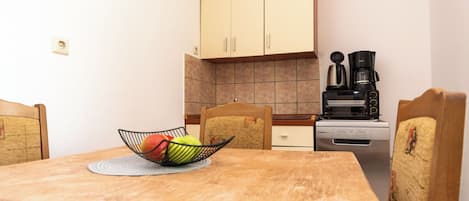 Appartement (A2) | Privékeuken | Een koelkast, een kookplaat, een waterkoker, kookgerei, borden en bestek