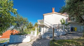 A two-story building with a balcony, a staircase leading to the entrance, and a view of the surrounding greenery. - Apartment Panorama Nicolas (Kastela)