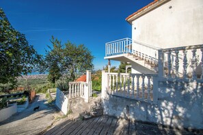 A building with a balcony, a staircase, and a view of the landscape. - Apartment Panorama Nicolas (Kastela)