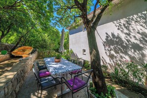 A patio with a table, chairs, and a kayak. - Apartment Antonija (Novi Vinodolski)