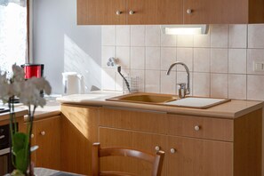 A modern kitchen with wooden cabinets, a stainless steel sink, and a built-in oven.