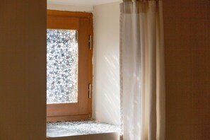 Una puerta con un diseño de mosaico, suelo de madera y una cortina.