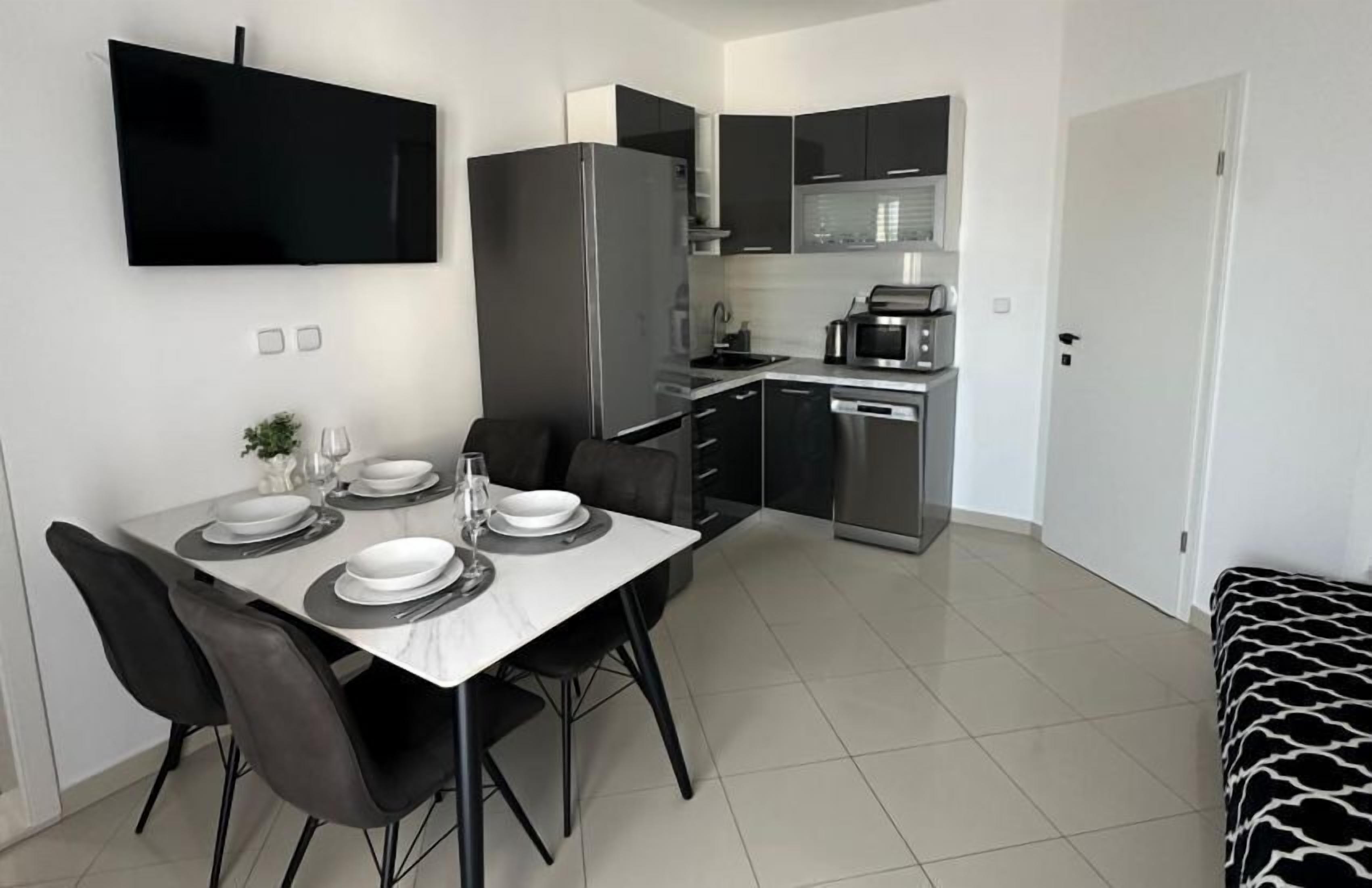 A modern kitchen with a built-in oven, microwave, and dishwasher.