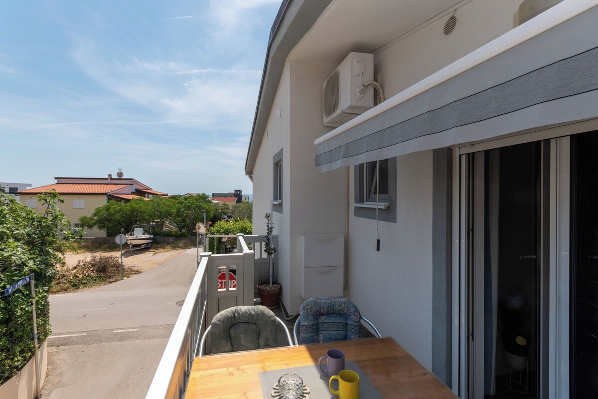 Ein Balkon mit Tisch, Stühlen und einem Stoppschild.