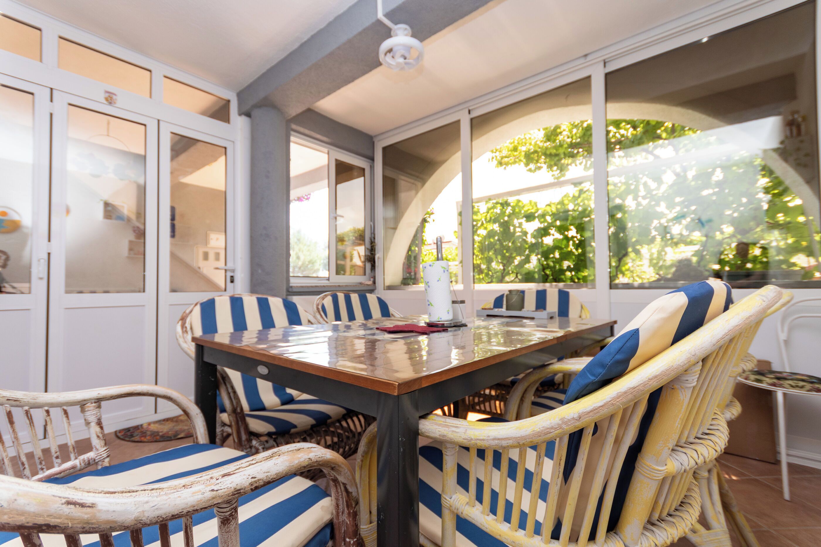 A dining area with a table, chairs, and large windows.