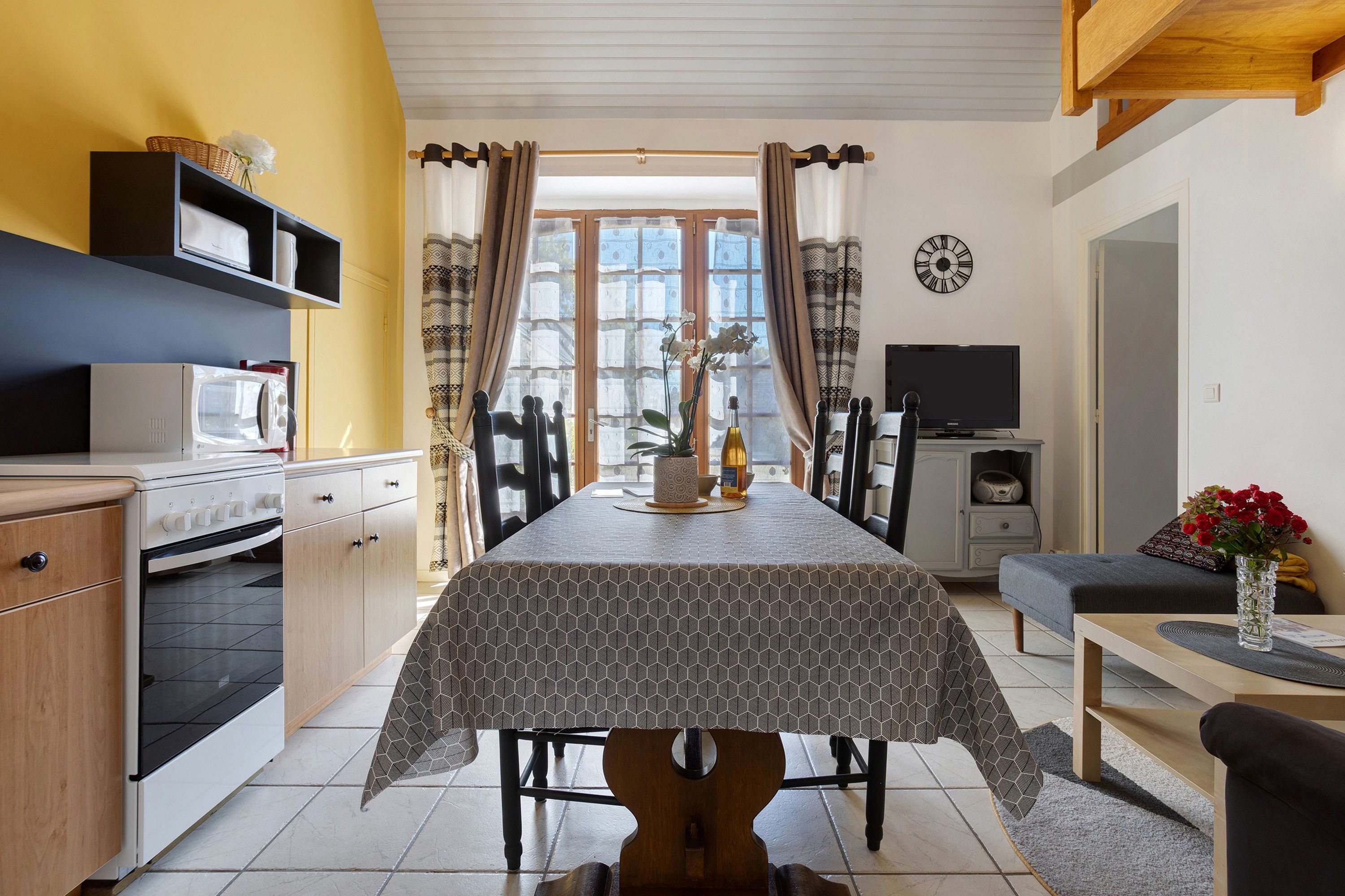 Une cuisine compacte équipée d’une table à manger, d’un four à micro-ondes et d’une cuisinière.