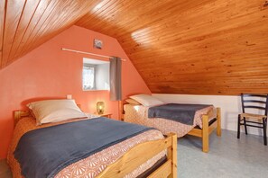 A cozy attic bedroom with two wooden beds, a small desk, and a chair. - Holiday home 'Maison de vacances' 10min from beaches and GR34 (Mahalon)