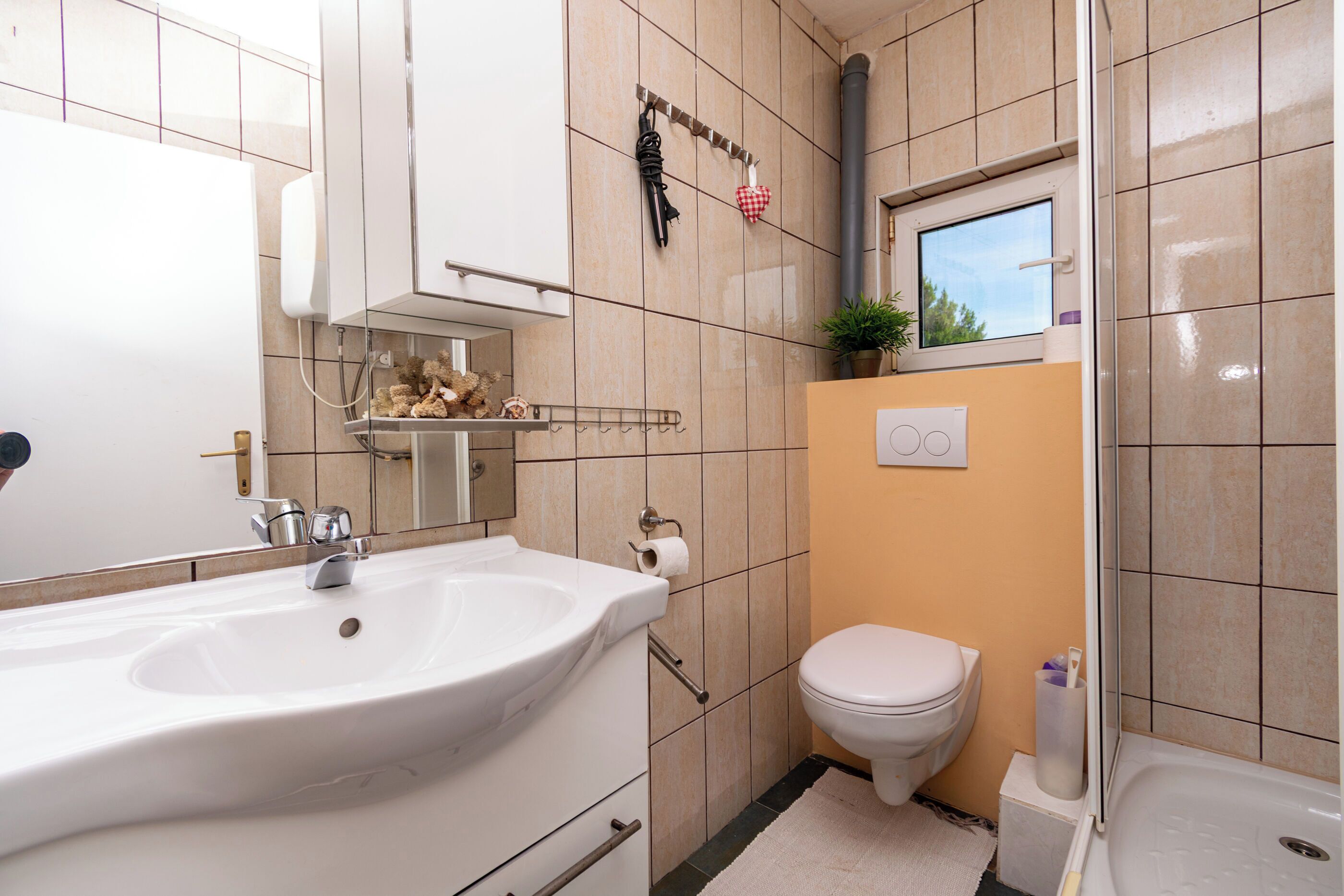 Un baño con lavamanos, inodoro y bañera.