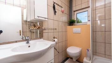 Un baño con lavamanos, inodoro y bañera.