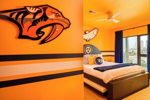 Ein Zimmer mit einem Bett, einem Deckenventilator und einem fensterbepflanzten Fenster.