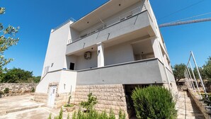 Ein mehrstöckiges Gebäude mit einem Balkon, einem Steinsockel und blauem Himmel.