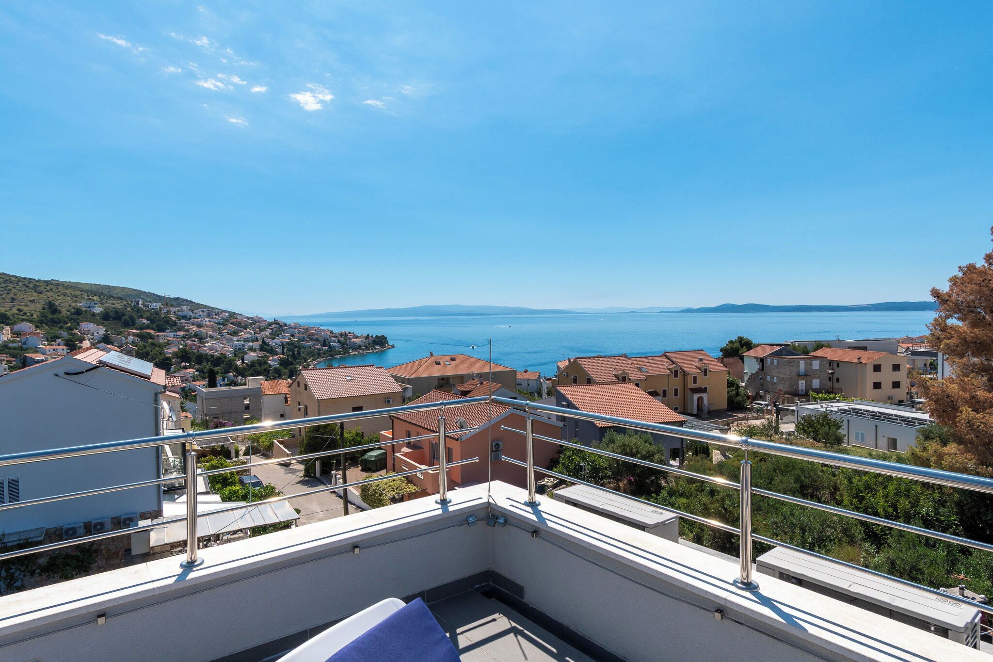 Ein Balkon mit Blick auf eine Küstenstadt und das Meer.