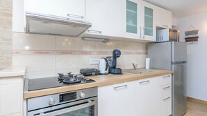 Een moderne keuken met een gasfornuis, oven, magnetron en koelkast.