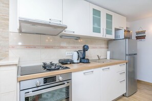 Eine moderne Küche mit Gasherd, Backofen, Mikrowelle und Kühlschrank.