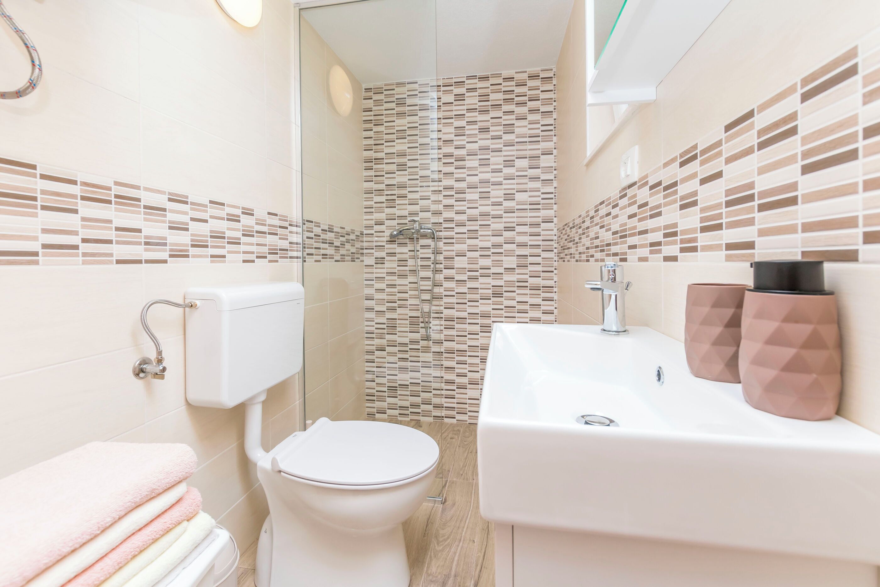 A modern bathroom with a toilet, sink, and shower.