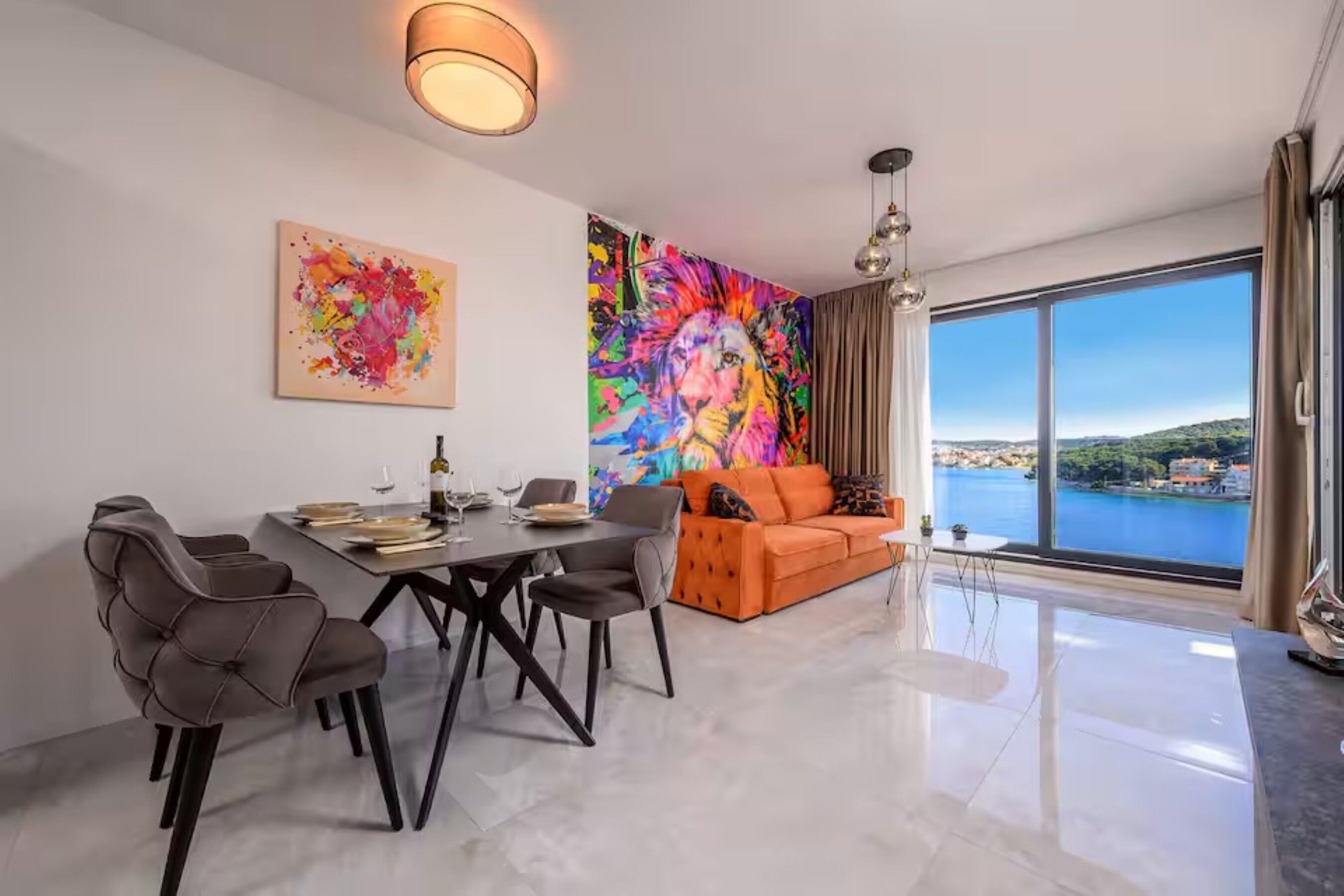 A modern dining area with a table, chairs, and artwork on the walls.