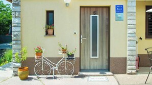 A building with a door marked '5', a sign indicating 'APARTMAN', and a welcome mat. - Apartment Nature (Klana)