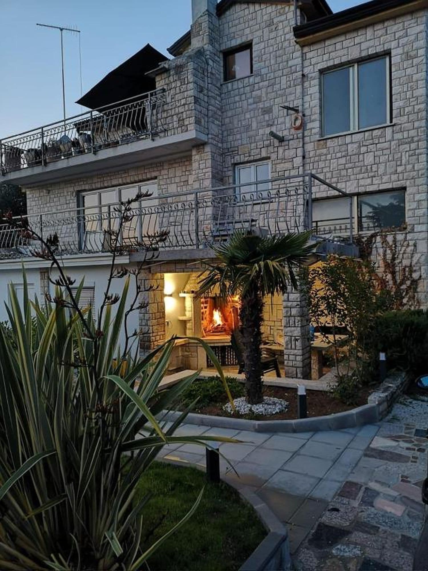 Un immeuble à plusieurs étages, doté d’une façade en pierre, d’un balcon et d’une cour intérieure agrémentée d’un foyer.
