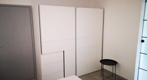 A room with a grey door, a white wardrobe, and a black stool. - Apartments Zanoff (Umag)