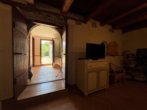 An open doorway leading to a balcony, a television on a cabinet, and a piano in the room. - Apartment Prelec (Crikvenica)