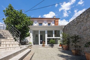 A building with a stone wall, a staircase, and potted plants. - House Danijel (Novi Vinodolski)