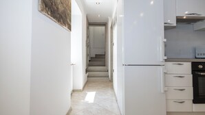 A narrow hallway with a kitchen area on the right, featuring white cabinetry and a microwave. - House Danijel (Novi Vinodolski)