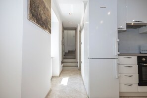 A narrow hallway with a kitchen area on the right, featuring white cabinetry and a microwave. - House Danijel (Novi Vinodolski)