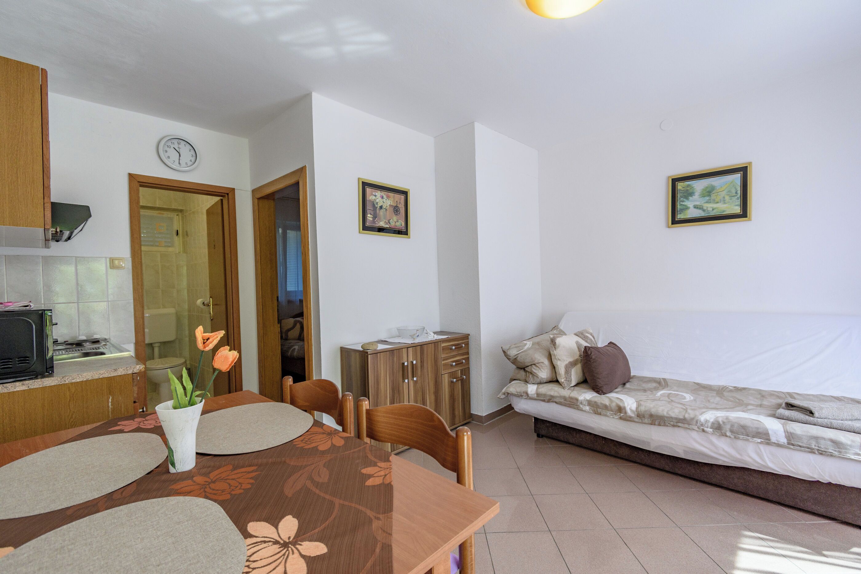 A compact living space with a kitchenette, dining area, and a bed.