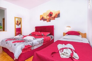 Ein Schlafzimmer mit zwei Betten, einem Spiegel, Bildern und einem Handtuchhalter.