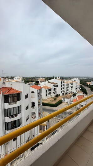 A residential building with balconies, a clear sky, and a distant view of other buildings. - Apartment 'Cozy  in Montechoro' with Balcony, Wi-Fi and Air Conditioning (Albufeira)