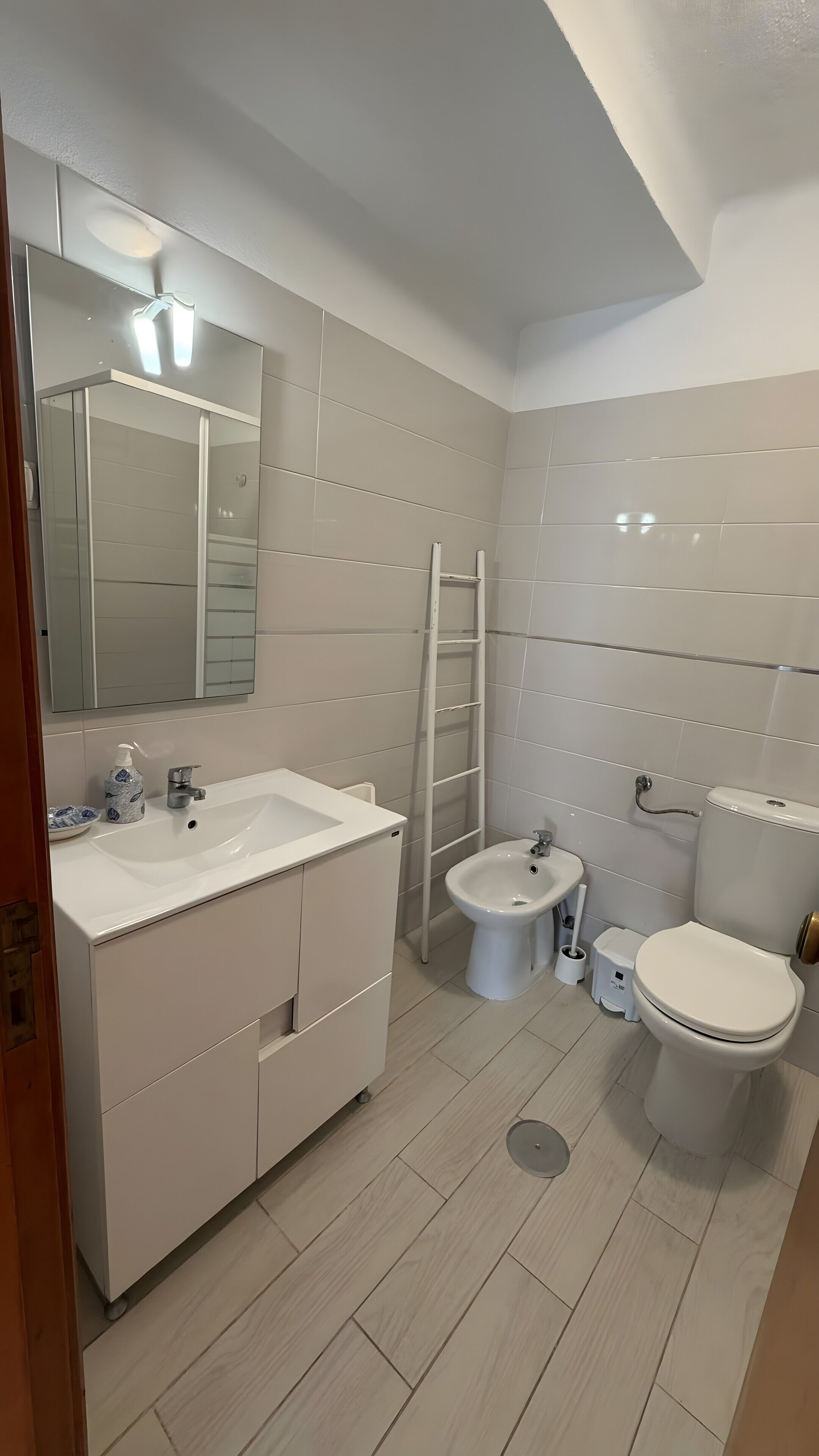 Ein modernes Badezimmer mit einem weißen Waschtisch, einer Toilette und einem Bidet.