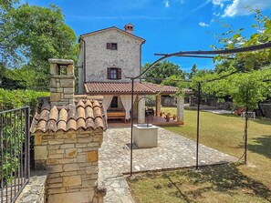 A stone house with a tiled roof, a stone staircase, and a covered patio area. - House Stancija Bursic (Marcana)