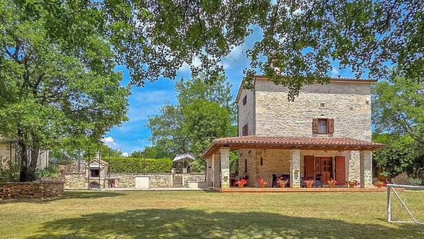 A stone building with a covered patio and a small garden area. - House Stancija Bursic (Marcana)
