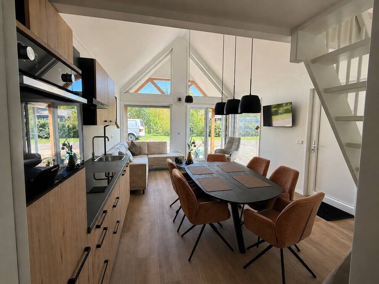 Una cucina moderna con zona pranzo, ampie finestre e una scala.