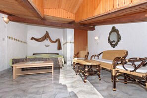 A room with a bed, a sofa, a table, and a mirror. - Apartments and Room Gulic (Rab)