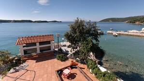 Um imóvel costeiro com pátio, área de estar externa e vista para o mar.