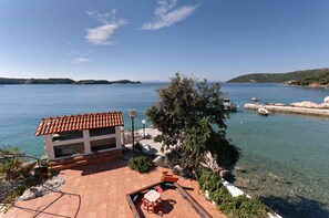 A coastal property with a patio, outdoor seating, and a view of the sea. - Apartments and Room Gulic (Rab)