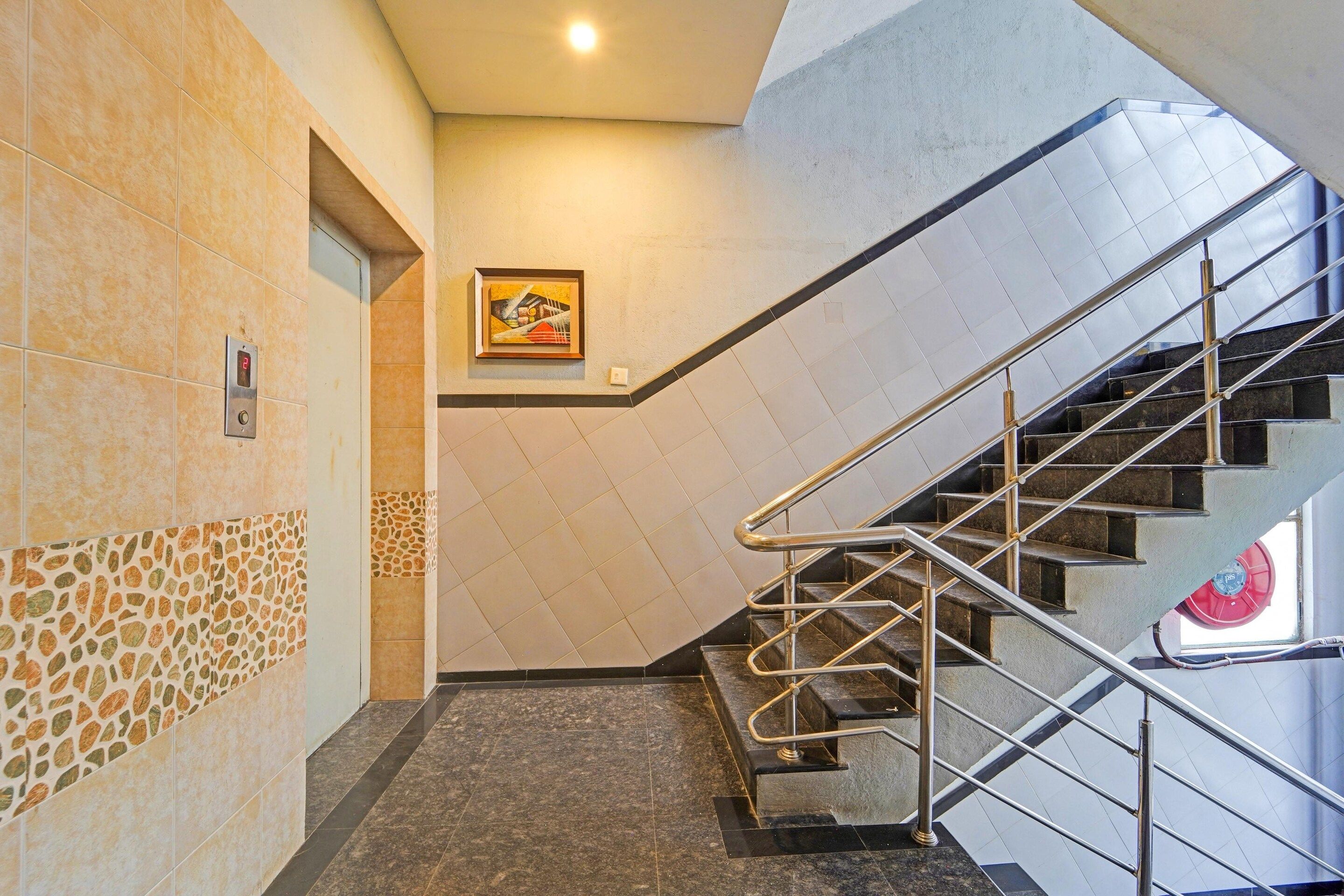 A staircase with metal railings and a tiled wall with a geometric pattern.