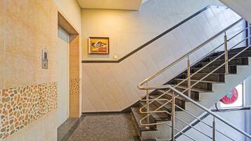 A staircase with metal railings and a tiled wall with a geometric pattern.