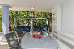 An outdoor dining area with a table, chairs, and a grill. - Apartments Wellness&spa (Dugi Rat)