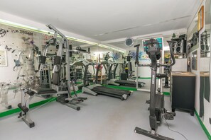 A gym with various exercise machines, a treadmill, and a mirrored wall. - Apartments Wellness&spa (Dugi Rat)