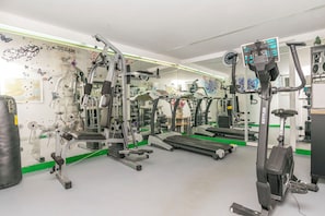 A gym with various exercise equipment, including treadmills and weight machines. - Apartments Wellness&spa (Dugi Rat)