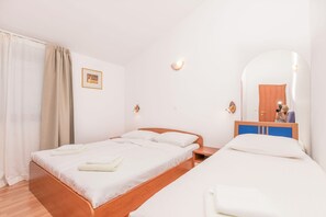 A hotel room with a wooden bed, a small bedside table, a mirror, and a wardrobe. - Apartments Wellness&spa (Dugi Rat)