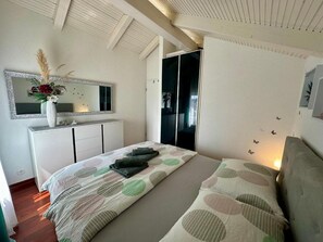 A bedroom with a bed, a dresser, a mirror, and a wardrobe. - Apartment Kinaya (Crikvenica)