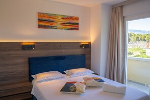 A hotel room with a large bed, a painting on the wall, and a view of the outdoors. - Apartment Blue Velvet Apartment (Lumbarda)