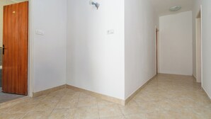 A hallway with a wooden door, a light switch, and a wall socket.