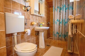 A bathroom with a toilet, sink, and shower. - Room Marta (Omisalj)