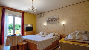 A bedroom with a bed, bedside table, TV, and a painting on the wall. - Room Marta (Omisalj)